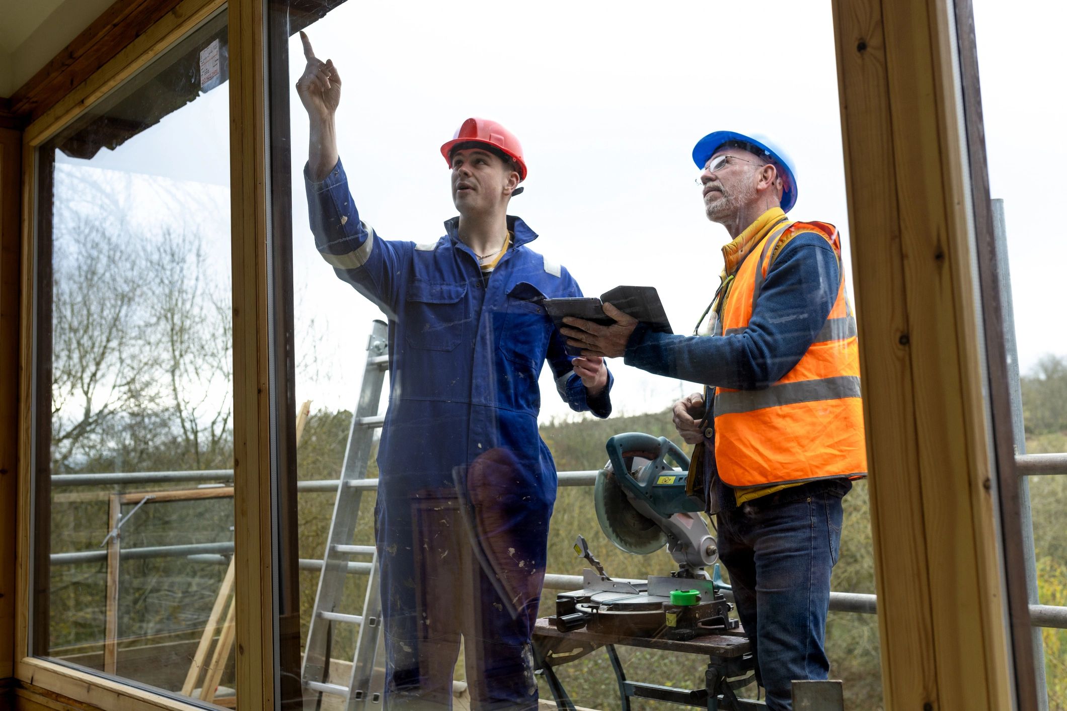 Building inspector discussing work with a construction worker on scaffolding